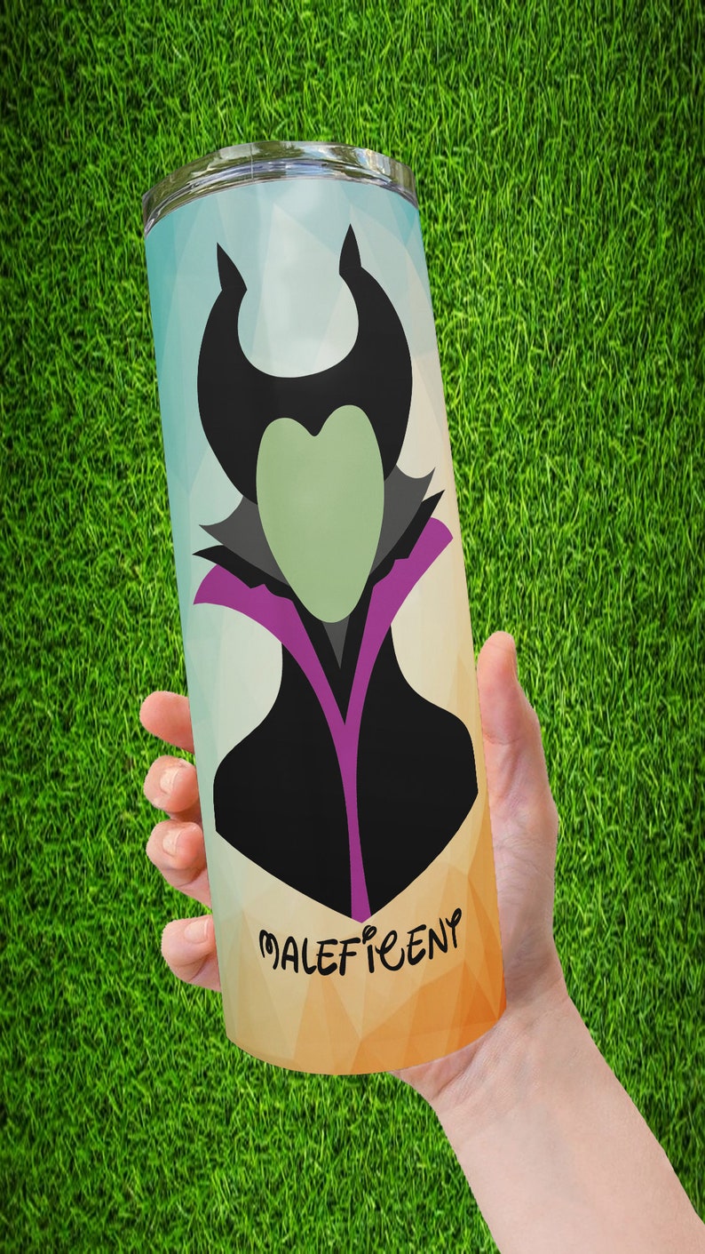 Peut inclure: Un gobelet en acier inoxydable avec une illustration stylis&eacute;e de Mal&eacute;fique. Le design comprend une silhouette noire avec des cornes, un visage vert et un col violet et noir. Le mot "Mal&eacute;fique" est imprim&eacute; dans une police stylis&eacute;e.