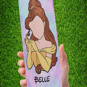 May include: A stainless steel tumbler with a colorful galaxy design featuring Belle from Beauty and the Beast. The tumbler has the word "Belle" written in gold script.