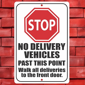 May include: A rectangular white sign with a red octagonal "STOP" symbol at the top. Below, bold black text reads "NO DELIVERY VEHICLES PAST THIS POINT" and "Walk all deliveries to the front door."