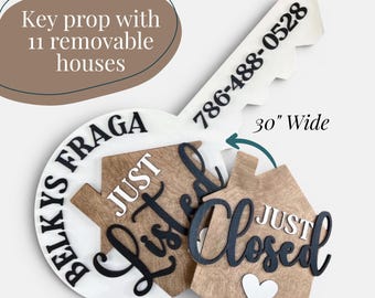 May include: A 30-inch wide white key-shaped prop featuring the text Belkys Fraga and 786-488-0528. It includes 11 removable wooden house-shaped pieces with the text Just Listed and Just Closed, along with a small white heart icon on the closed house.