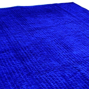K&ouml;nnte beinhalten: Nahaufnahme eines blauen gesteppten Stoffes mit einer strukturierten Oberfl&auml;che.