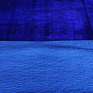 K&ouml;nnte beinhalten: Eine blaue Samtdecke mit einem gesteppten Muster auf der Unterseite.