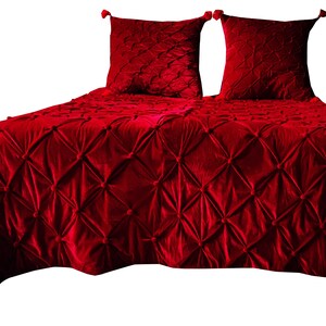 K&ouml;nnte beinhalten: Ein roter, gesteppter Bett&uuml;berwurf aus Samt mit zwei passenden Kissenbez&uuml;gen. Der Bett&uuml;berwurf hat ein Rautenmuster mit Knopfkn&ouml;pfen.