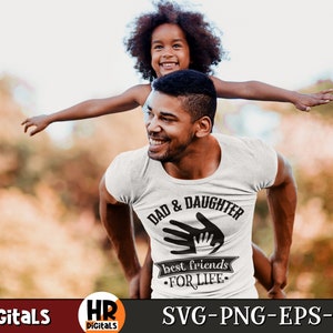 Op de afbeelding: Een wit T-shirt met een zwart grafisch ontwerp met de tekst "Dad & Daughter best friends for life" met een handafdrukdesign.