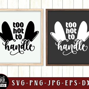 May include: Two black oven mitts with the text "too hot to handle" in white. The image is in a white frame with a wood border.