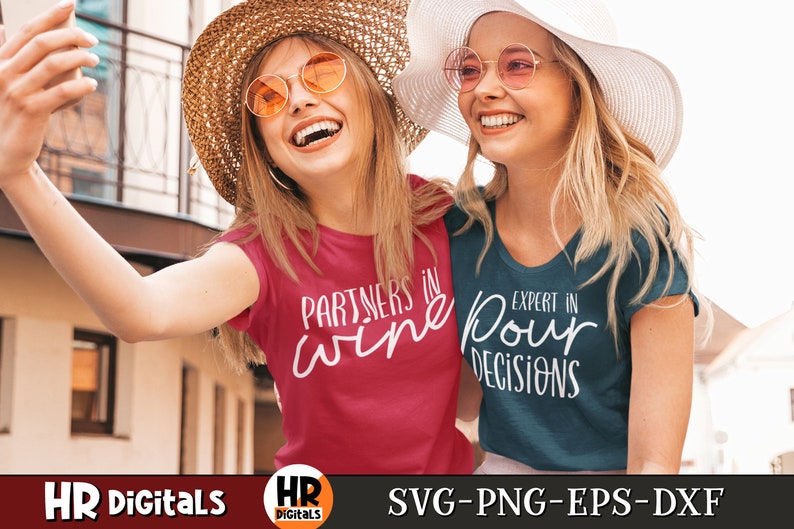 Puede incluir: Dos mujeres con sombreros de paja y gafas de sol sonr&iacute;en y se toman una selfie. Una mujer lleva una camiseta roja con el texto "Partners in wine" y la otra lleva una camiseta azul con el texto "Expert in pour decisions".