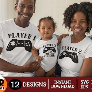 Op de afbeelding: Een set van drie witte T-shirts met zwarte tekst en een zwarte afbeelding van een videogamecontroller. De shirts zeggen "Speler 1", "Speler 2" en "Speler 3 is het spel ingegaan".