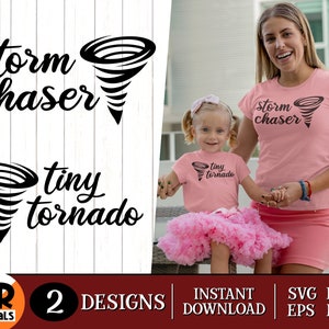 Puede incluir: Dos camisetas rosas con texto negro y un gráfico de tornado. La camiseta más grande dice "cazador de tormentas" y la más pequeña dice "pequeño tornado".