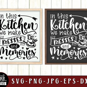 May include: Two black and white signs with a wood frame. The signs say "In this kitchen we make messes and memories" with a stylized arrow and a cup and saucer graphic.