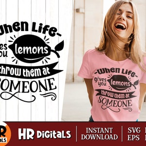 Könnte beinhalten: Ein schwarz-weißes Grafikdesign mit dem Text "When Life gives you lemons throw them at SOMEONE". Die Grafik zeigt eine Zitrone mit Stiel und Blättern. Der Text ist in einer stilisierten Schriftart.