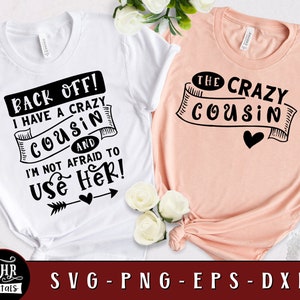 Puede incluir: Dos camisetas blancas con texto negro. La primera camiseta dice "Back off! I have a crazy cousin and I'm not afraid to use her!" con una flecha y un corazón. La segunda camiseta dice "The crazy cousin" con una pancarta y un corazón.