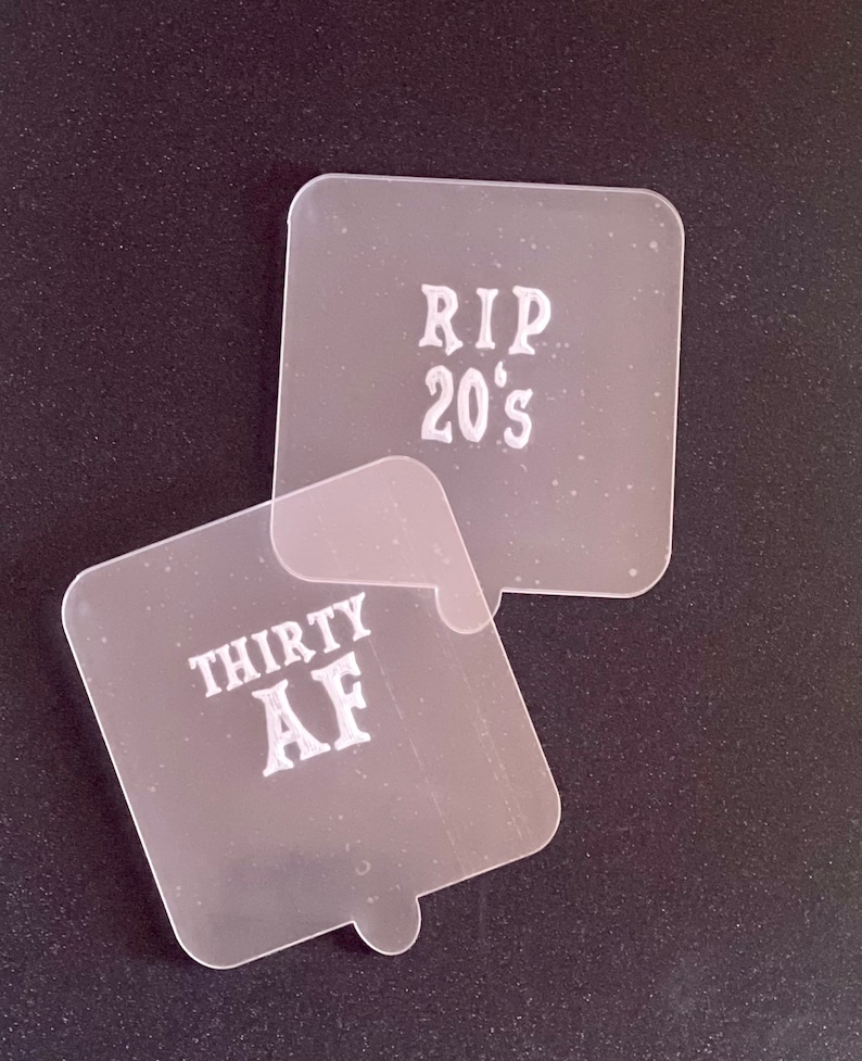 May include: Two clear plastic stencils with white lettering. The top stencil says "RIP 20's" and the bottom stencil says "THIRTY AF".
