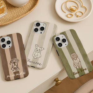 Könnte beinhalten: Drei Handyhüllen mit Hundeillustrationen. Eine Hülle ist braun mit vertikalen Streifen und dem Text "mira mota". Eine andere ist beige mit einer Hundeillustration und dem Namen "Vivienne". Die dritte ist grün mit einer Hundeillustration und dem Namen "Bea Vine".