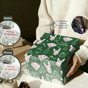 May include: A square gift box wrapped in dark green paper featuring a repeating white line-art pattern of dog faces, Christmas trees, and ornaments with the text merry christmas. Includes a circular inset showing a black dog photo.