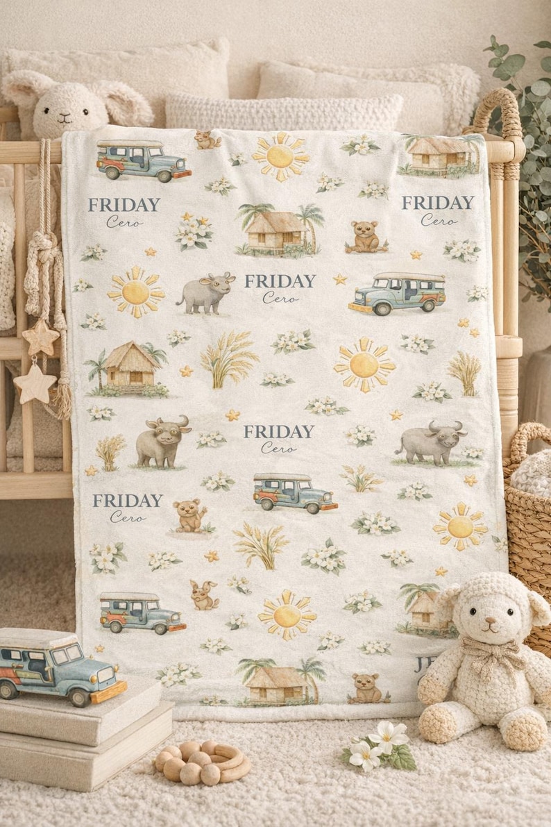 May include: A white baby blanket with a repeating pattern of a blue jeepney, sun, hut, bear, and water buffalo. The text "FRIDAY Cero" is printed on the blanket. The blanket is surrounded by stuffed animals.