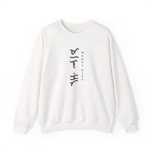 May include: A white long-sleeve crewneck sweatshirt featuring black text printed vertically on the centre chest. The design includes Baybayin script characters arranged in a column next to the words "MAHAL KITA" written in a simple serif font.