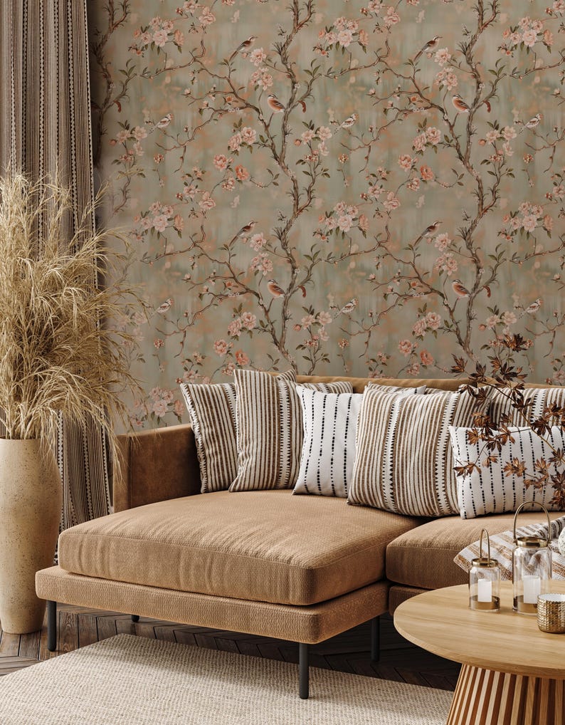 May include: Wallpaper featuring a repeating pattern of brown tree branches, pink flowers, and small birds against a muted sage green background. The design includes intricate floral details and avian figures spread across the vertical surface.