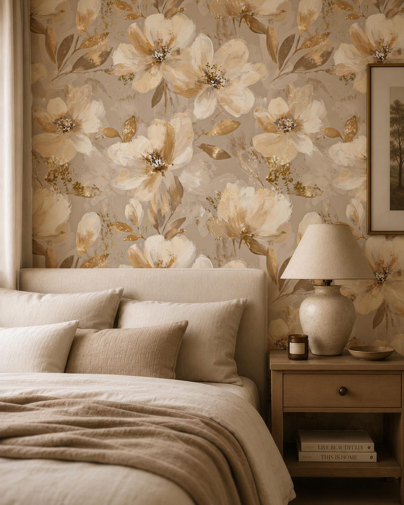 May include: Wallpaper featuring a large-scale floral pattern in shades of beige, cream, and metallic gold. The design includes painterly flower blossoms and foliage set against a neutral background, creating a repeating botanical motif.