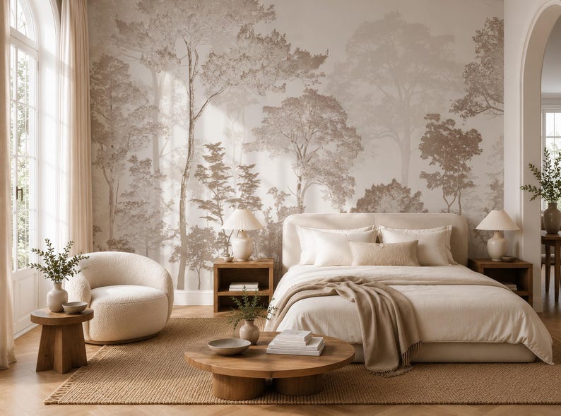 May include: A bedroom featuring a large wall mural with a sepia-toned forest landscape. The room includes a cream-coloured bed with matching pillows, a round cream armchair, two wooden nightstands with lamps, and a low round wooden coffee table.
