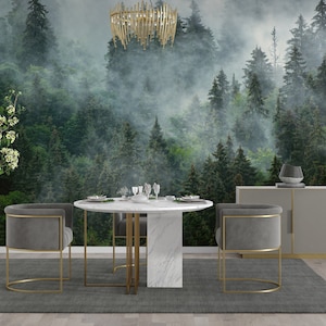 May include: A dining room with a gray rug, a round marble table with gold legs, and two gray velvet chairs with gold frames. The wall behind the table features a mural of a misty forest with tall green trees.