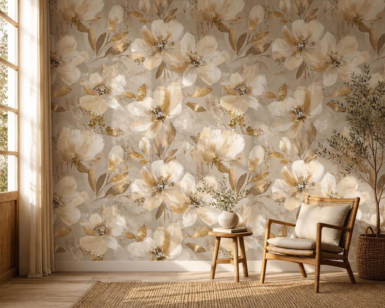 May include: Wallpaper featuring a repeating pattern of large, painterly flowers in shades of cream, beige, and soft gold against a neutral background. The floral design includes delicate petals and foliage with subtle metallic gold accents.