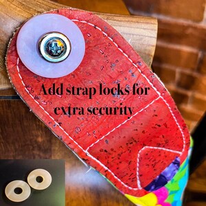 May include: A red strap lock with white stitching and a light purple button. The text "Add strap locks for extra security" is visible. Two additional light-colored strap locks are in the lower left corner.