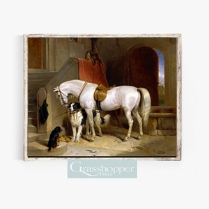May include: A painting depicting a white horse standing in a stable with two dogs. The horse is wearing a saddle and bridle. The dogs are a black and white border collie and a smaller brown dog. The stable is constructed of stone and has a wooden door.