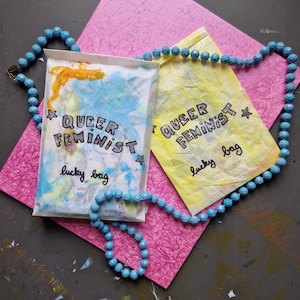 queer feminist lucky bag - deine Überraschungstüte mit visuellen Leckereien // feministisch, LGBTIQA, neurodivergent, dinos, alles ist dabei