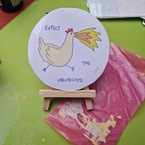 EXPECT THE UNEXPECTED - transparenter Sticker mit feuerspeiendem Huhn