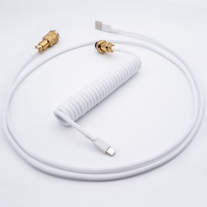May include: White coiled USB cable with gold connectors. The cable is coiled and has a white braided exterior.