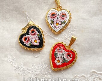 May include: Three heart-shaped pendants with floral mosaic designs. The pendants are made of gold-toned metal and feature intricate mosaic patterns in red, white, and black.