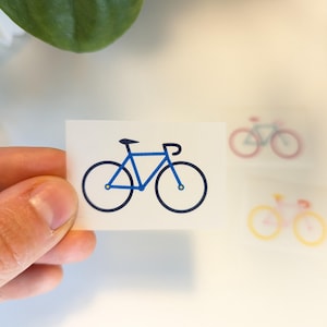 Könnte beinhalten: Eine blaue Fahrradsilhouette auf weißem Hintergrund. Das Fahrrad hat einen dünnen Rahmen und zwei Räder.