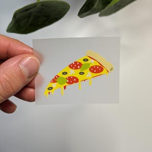 Könnte beinhalten: Ein transparenter Aufkleber mit einer Cartoon-Illustration eines Pizzastücks mit Pepperoni, Käse und grünen Paprikaschoten. Die Pizza hat einen gelben Rand und tropft mit geschmolzenem Käse.