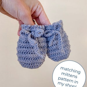 May include: A pair of gray crocheted baby mittens with a tied bow detail. Matching mittens pattern in my shop!
