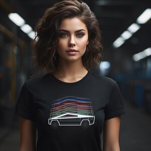 May include: A black t-shirt with a white outline of a pickup truck with a green and red design on the side. The truck is a stylized version of the Cybertruck.