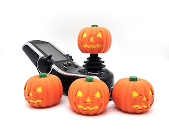 May include: Four orange jack-o'-lantern shaped decorations with a carved face and glowing eyes. One jack-o'-lantern is on top of a black joystick.