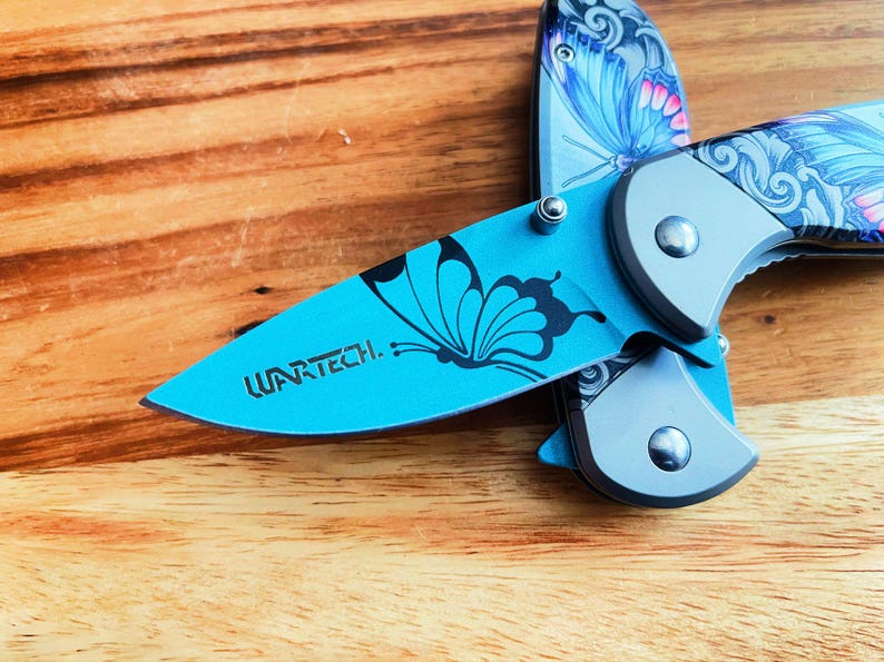 May include: A blue pocket knife with a butterfly design and the word "WARTECH" engraved on the blade.