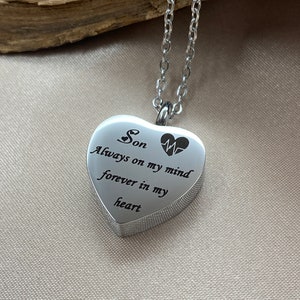 Può includere: Collana con ciondolo a forma di cuore argentato e catena. Il ciondolo ha un'iscrizione che recita "Son Always on my mind forever in my heart" e un piccolo cuore e un simbolo ECG.
