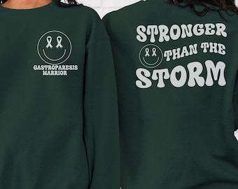 May include: Green sweatshirt with a white smiley face and the text "Gastroparesis Warrior" on the front and "Stronger Than The Storm" on the back.