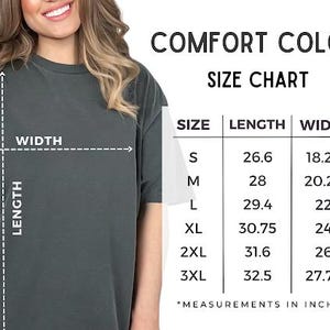 May include: A dark charcoal gray t-shirt shown with a Comfort Colors size chart. The chart lists sizes S through 3XL with corresponding length and width measurements in inches, ranging from 26.6 to 32.5 inches in length and 18.25 to 27.75 inches in width.