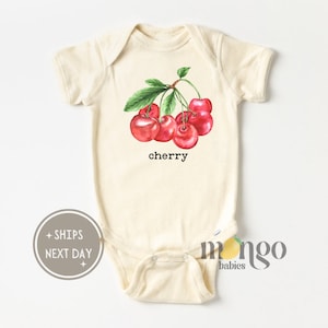May include: A cream-colored baby onesie with a watercolor illustration of red cherries on a green stem. The onesie has the word "cherry" printed in black below the cherries.