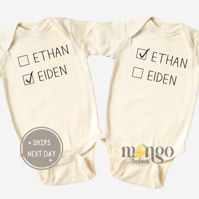 Peut inclure: Deux bodies b&eacute;b&eacute; &agrave; manches longues de couleur cr&egrave;me avec des cases &agrave; cocher noires et du texte. Un body a une coche &agrave; c&ocirc;t&eacute; de "Eiden" et l'autre a une coche &agrave; c&ocirc;t&eacute; de "Ethan".