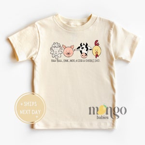 May include: A cream colored short-sleeved t-shirt with a graphic of a sheep, pig, cow, and chicken with the text "BAA-BAA, OINK, MOO, & COCK-A-DOODLE DOO."