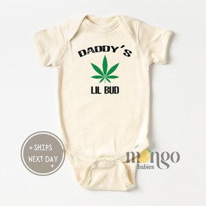 May include: A white baby onesie with the text "Daddy's Lil Bud" and a green marijuana leaf graphic.