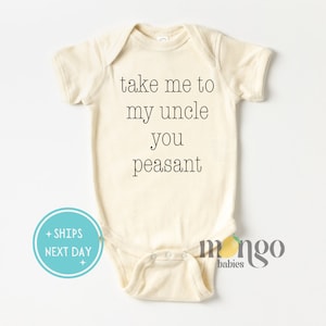 May include: A cream-colored baby onesie with the text "take me to my uncle you peasant" printed in black.