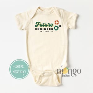 May include: A cream-colored baby onesie with the text "Future Engineer in Training" in green and orange lettering with gear graphics.