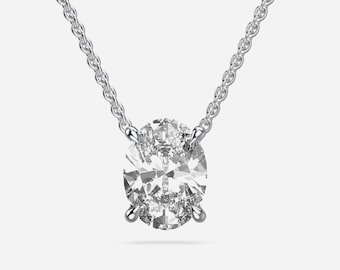 May include: A silver chain necklace with a large oval-shaped diamond pendant. The diamond is surrounded by smaller diamonds.