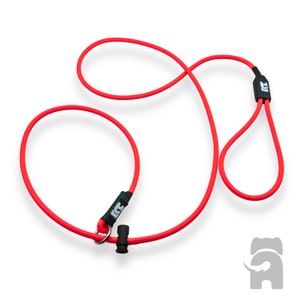 May include: Red dog leash with a black loop handle and a metal ring. The leash is made of a soft, flexible material.