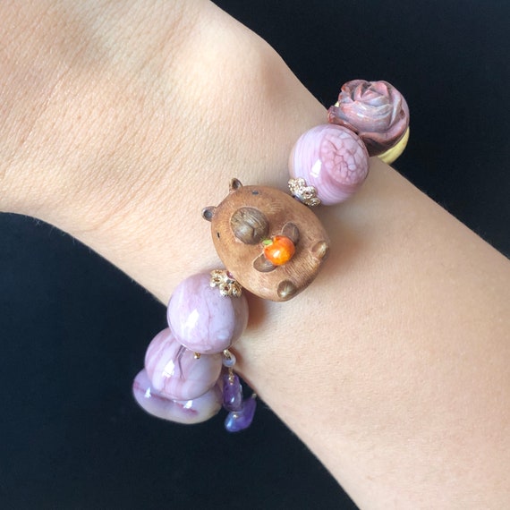 GLASS BEAD RING 2 MM LAVENDEL W/LION CHARM GLASS BEAD RING 2 MM LAVENDEL W/LION CHARM