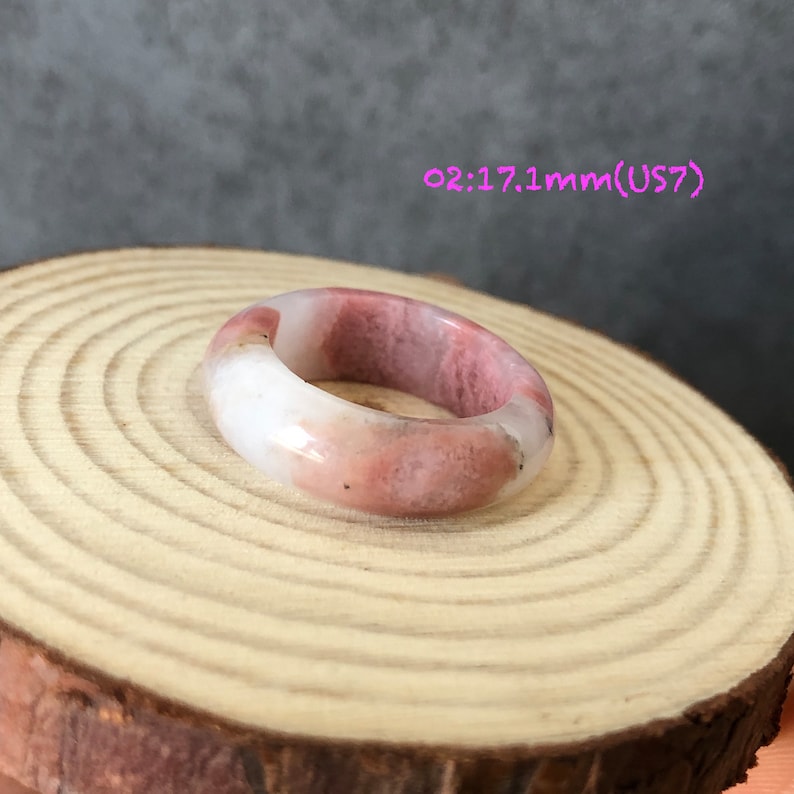 Pode incluir: Um anel de pedra polida rosa e branco. O anel tem 17,1 mm de tamanho e &eacute; um tamanho 7.